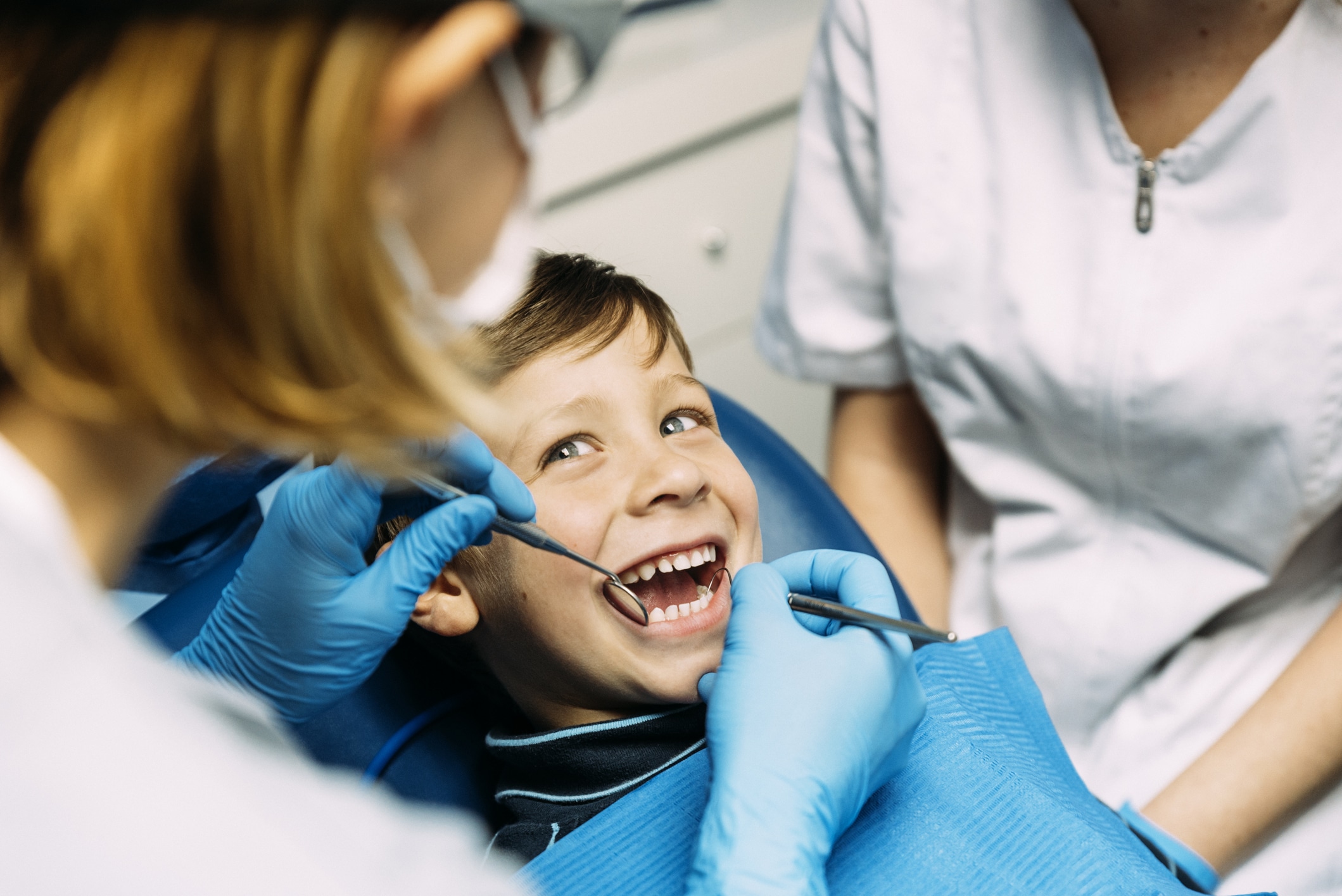 Dentists with a young boy patient during a dental cleaning and checkup visit